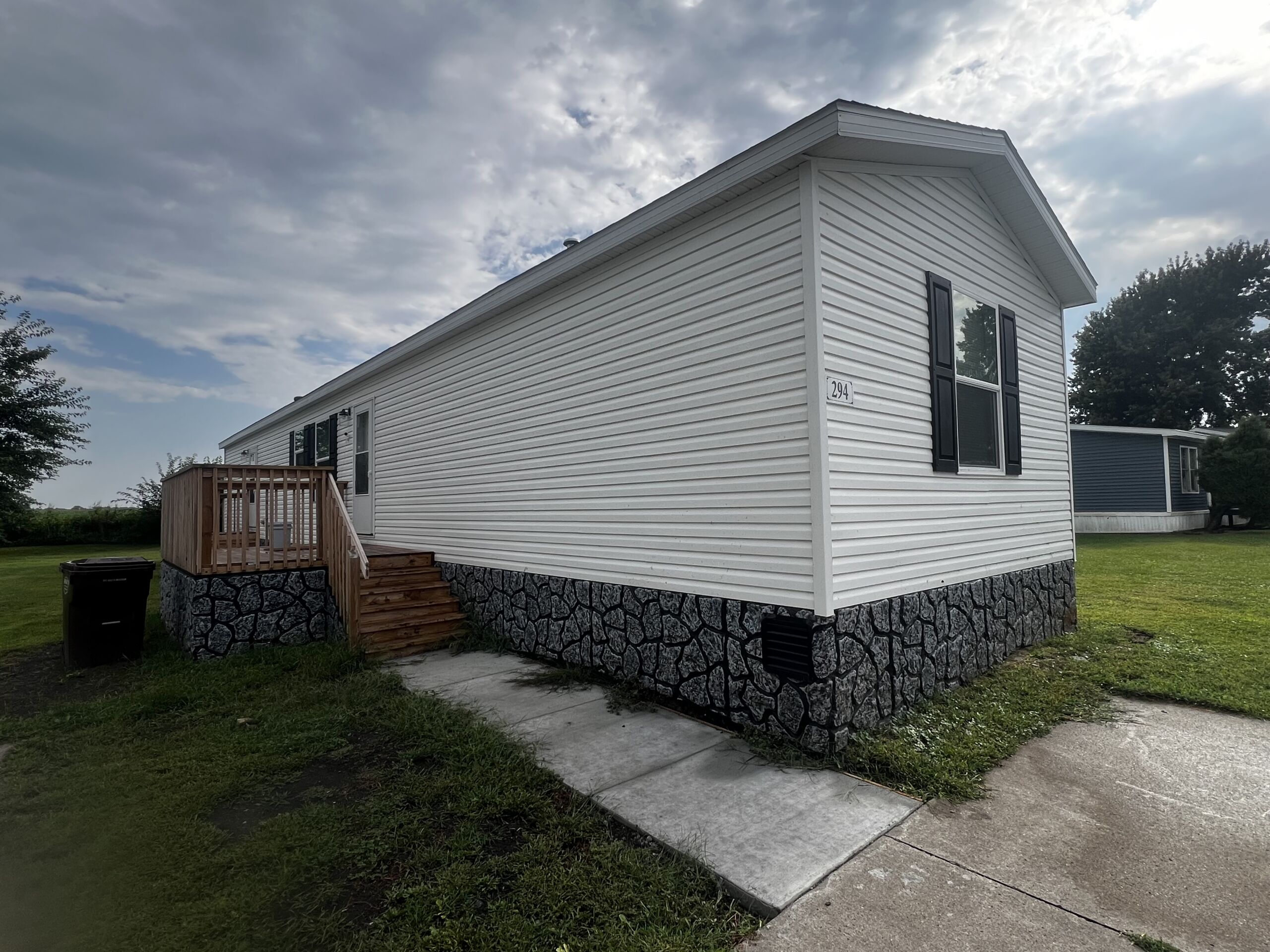 White siding and grey vinyl rock skirting